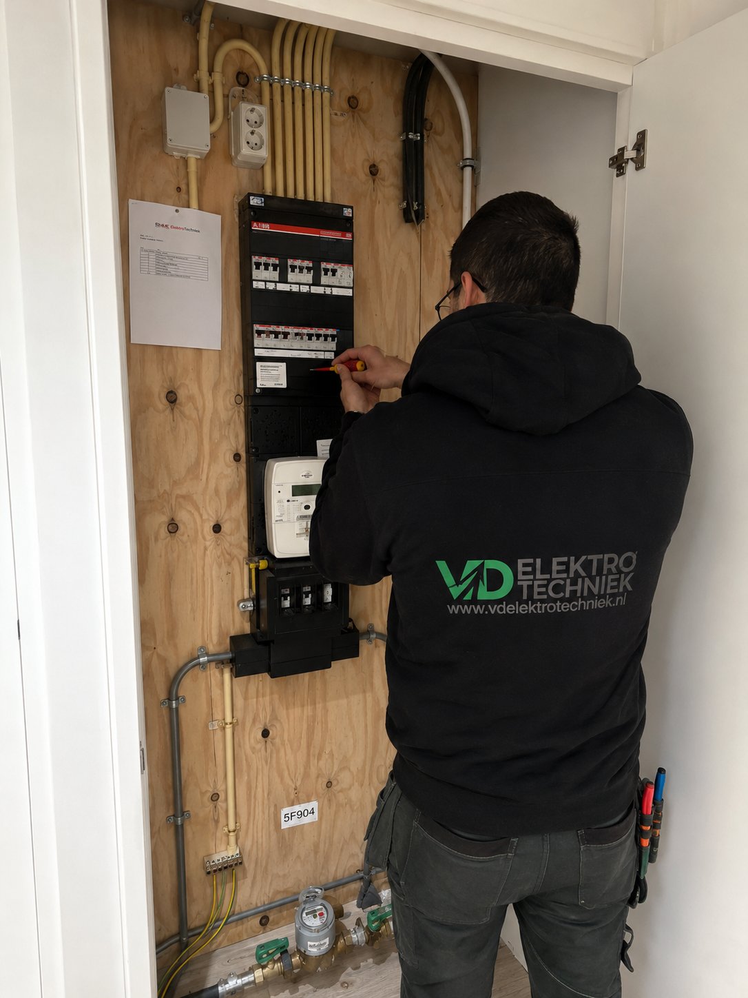 Aron van VD Elektrotechniek werkt aan een groepenkast in Rotterdam