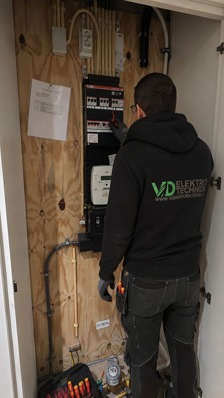 Aron van VD Elektrotechniek aan het werk aan een groepenkast in Rotterdam